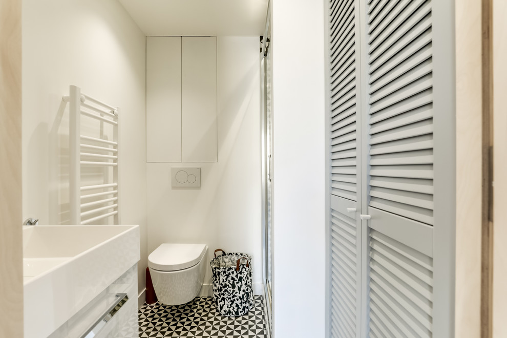 Exempel på ett mellanstort skandinaviskt badrum med dusch, med luckor med lamellpanel, grå skåp, en dusch i en alkov, en vägghängd toalettstol, svart och vit kakel, vita väggar och dusch med gångjärnsdörr