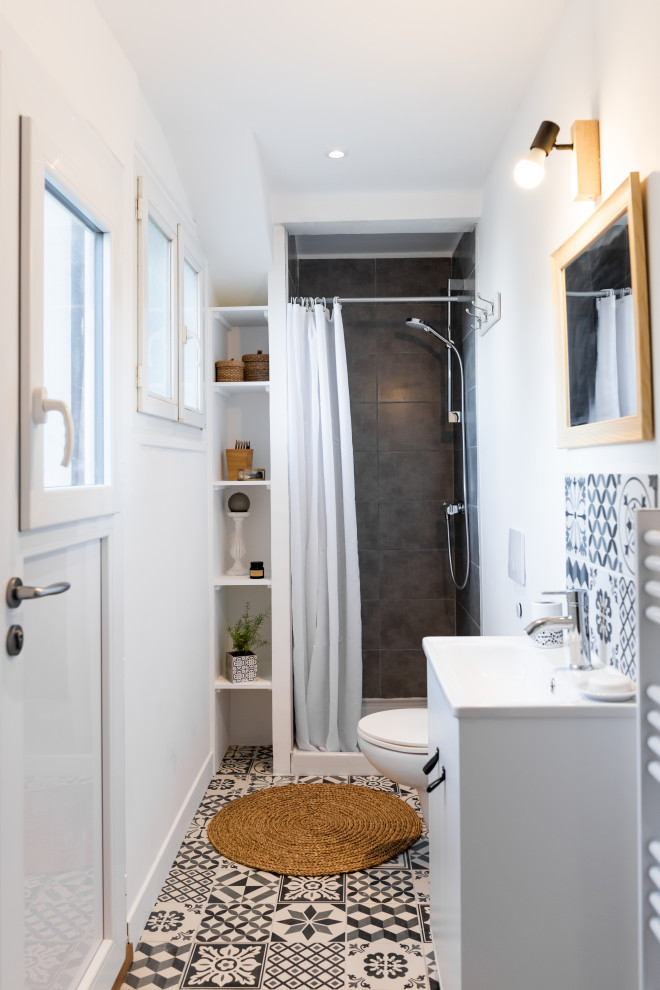Inspiration för ett litet funkis en-suite badrum, med luckor med profilerade fronter, en dusch i en alkov, en vägghängd toalettstol, svart och vit kakel, cementkakel, vita väggar, cementgolv, ett undermonterad handfat, svart golv och dusch med duschdraperi