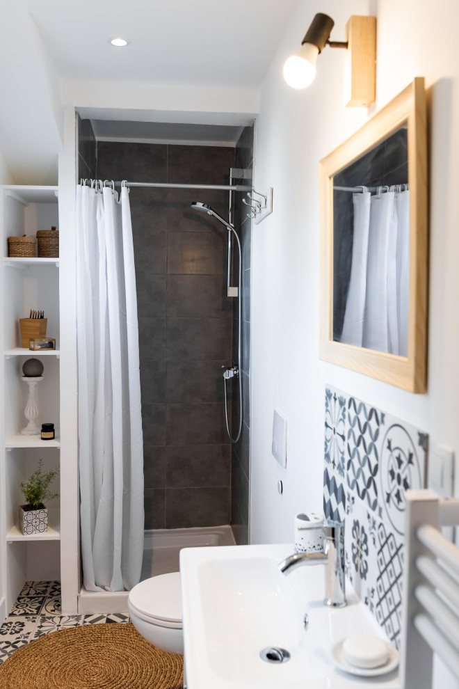 Idéer för att renovera ett litet funkis en-suite badrum, med luckor med profilerade fronter, en dusch i en alkov, en vägghängd toalettstol, svart och vit kakel, cementkakel, vita väggar, cementgolv, ett undermonterad handfat, svart golv och dusch med duschdraperi