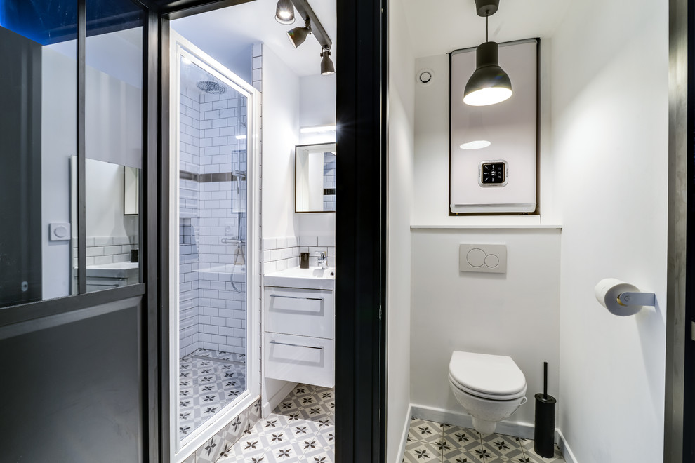 Modelo de cuarto de baño contemporáneo pequeño con sanitario de pared, paredes blancas, baldosas y/o azulejos de cemento y suelo de azulejos de cemento