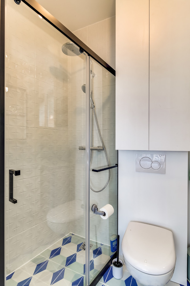 Idéer för små retro badrum med dusch, med en kantlös dusch, en vägghängd toalettstol, vit kakel, keramikplattor, vita väggar, klinkergolv i keramik, ett integrerad handfat, kaklad bänkskiva, flerfärgat golv och dusch med skjutdörr
