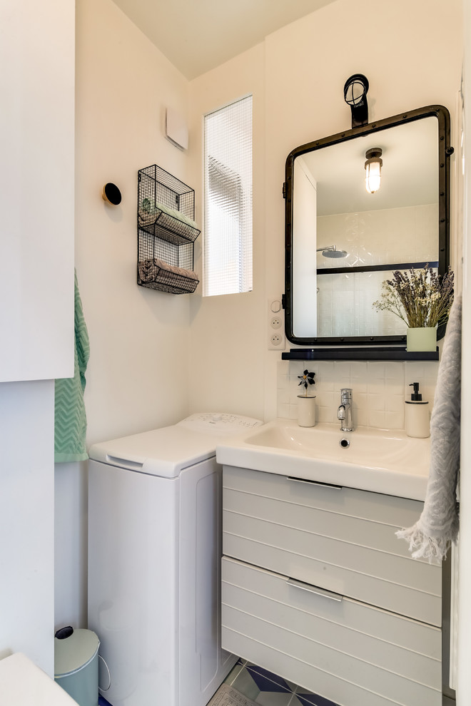 パリにあるお手頃価格の小さなミッドセンチュリースタイルのおしゃれなバスルーム (浴槽なし) (バリアフリー、壁掛け式トイレ、白いタイル、サブウェイタイル、白い壁、セメントタイルの床、壁付け型シンク、マルチカラーの床、引戸のシャワー) の写真