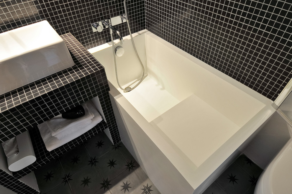 Пример оригинального дизайна: маленькая главная ванная комната в современном стиле с полновстраиваемой ванной, инсталляцией, черной плиткой, плиткой мозаикой, черными стенами, полом из керамогранита и серым полом для на участке и в саду