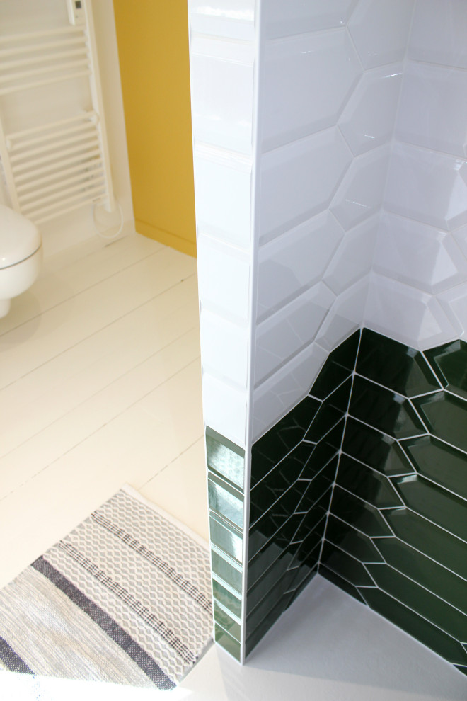 Immagine di una piccola stanza da bagno con doccia minimalista con doccia alcova, piastrelle verdi, piastrelle in ceramica, pareti gialle, pavimento in legno verniciato, WC sospeso e pavimento bianco