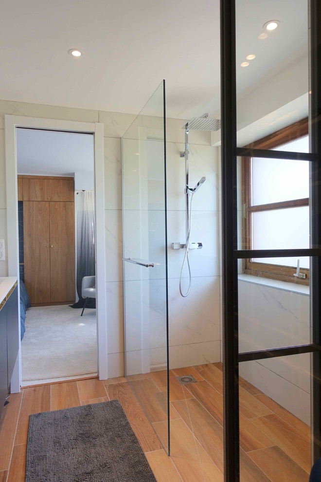 This is an example of a small contemporary shower room bathroom in Paris with glass-front cabinets, black cabinets, a built-in shower, white tiles, marble tiles, white walls, light hardwood flooring, a vessel sink, marble worktops, brown floors, a sliding door and white worktops.