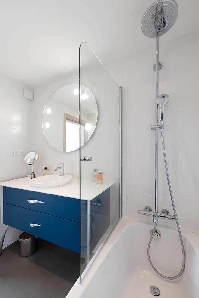 Inspiration pour une salle de bain design de taille moyenne avec des portes de placard bleues, une baignoire encastrée, un combiné douche/baignoire, un carrelage blanc, des carreaux de céramique, un mur blanc, sol en béton ciré, un plan vasque, un plan de toilette en bois, un sol gris et un plan de toilette blanc.