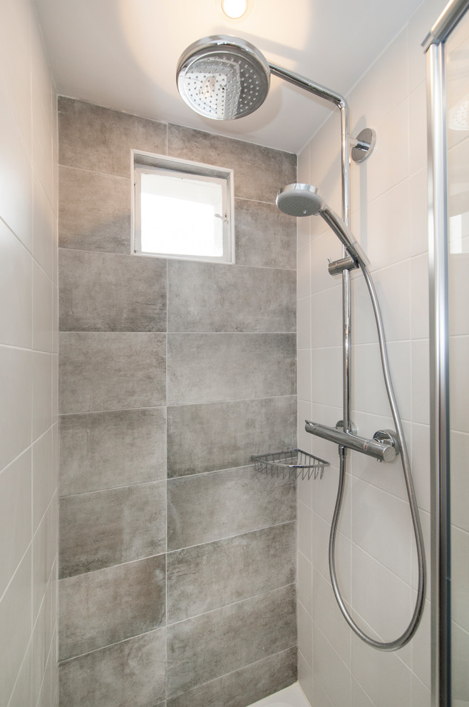 Idées déco pour une salle de bain principale contemporaine de taille moyenne avec une douche à l'italienne, un carrelage gris, des carreaux de céramique, un mur blanc et une cabine de douche à porte battante.