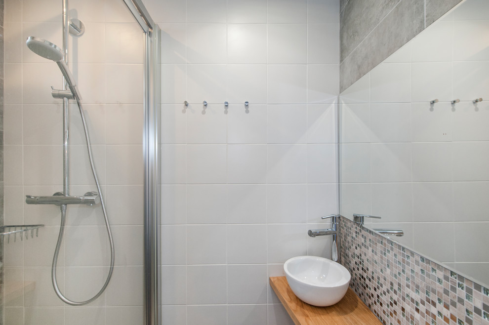 Réalisation d'une salle de bain principale design de taille moyenne avec une douche à l'italienne, un carrelage gris, des carreaux de céramique, un mur blanc et une cabine de douche à porte battante.