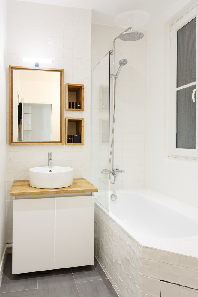 Esempio di una piccola stanza da bagno padronale nordica con ante lisce, ante bianche, vasca sottopiano, WC sospeso, piastrelle bianche, piastrelle in ceramica, lavabo da incasso, top in legno e top beige