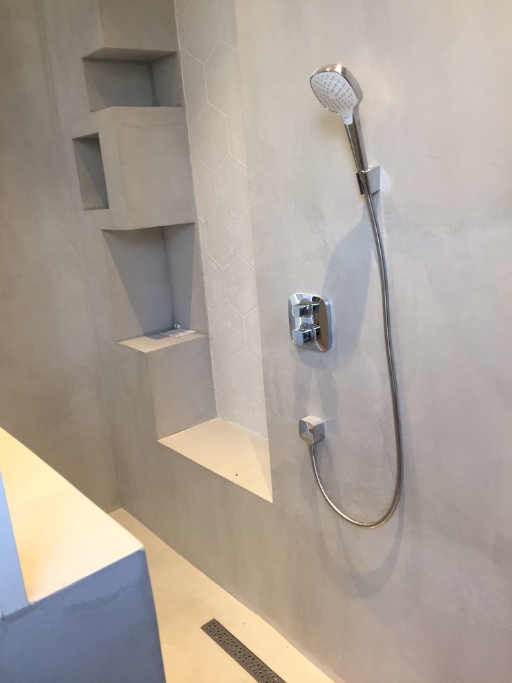 Стильный дизайн: главная ванная комната среднего размера в современном стиле с отдельно стоящей ванной, открытым душем, бежевой плиткой, белой плиткой, керамической плиткой, серыми стенами, полом из цементной плитки, монолитной раковиной, белым полом и открытым душем - последний тренд