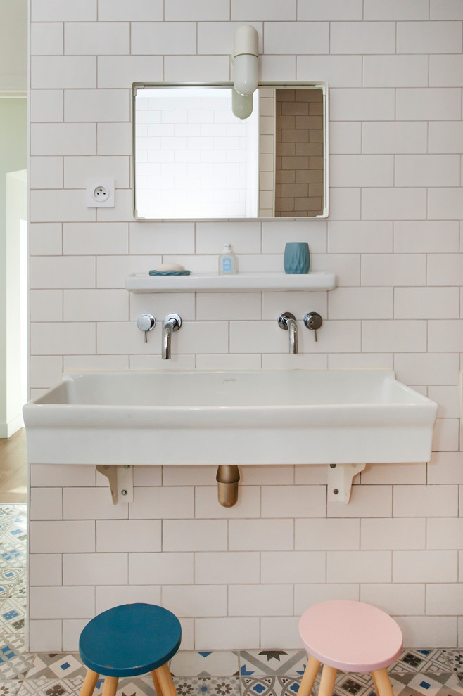 Exempel på ett minimalistiskt badrum för barn, med vit kakel, tunnelbanekakel, ett avlångt handfat och flerfärgat golv