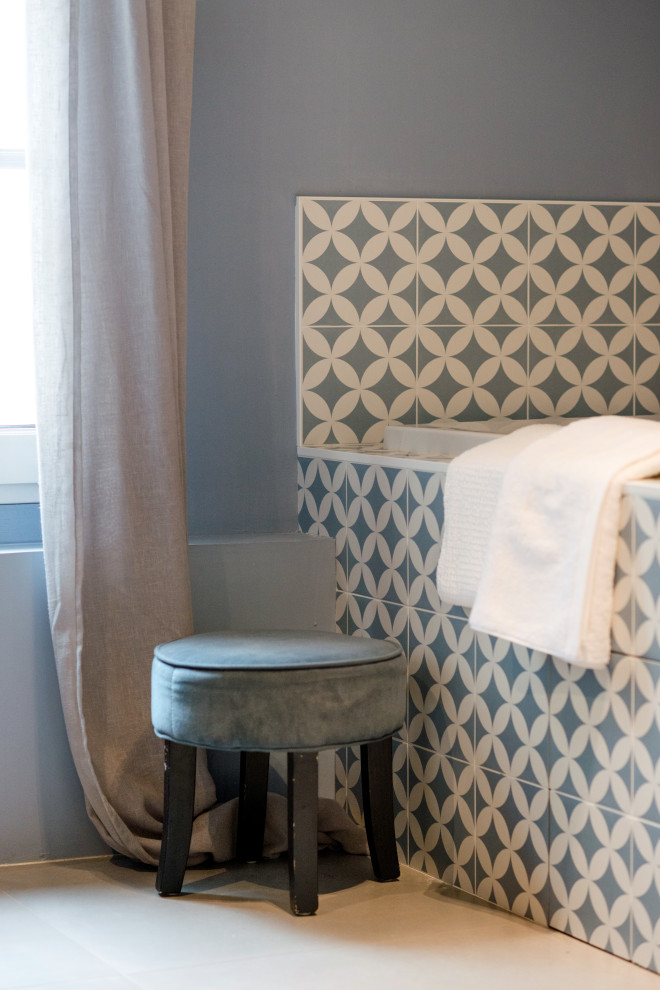 Modern inredning av ett mellanstort brun brunt en-suite badrum, med bruna skåp, ett platsbyggt badkar, blå kakel, cementkakel, blå väggar, klinkergolv i keramik, ett fristående handfat, träbänkskiva, grått golv och med dusch som är öppen