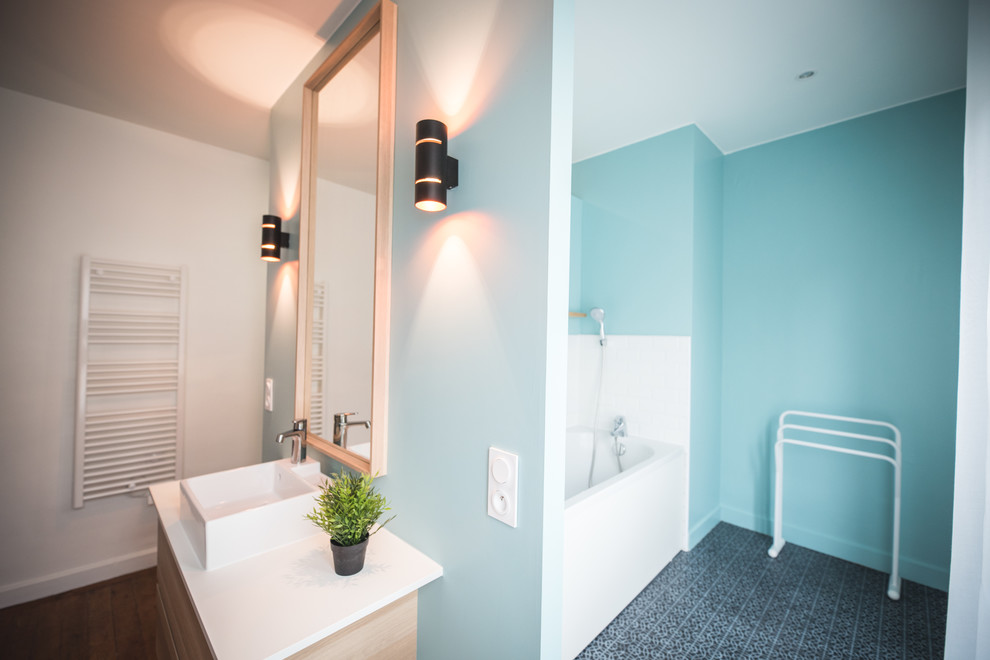 Example of a large danish master white tile and subway tile light wood floor and brown floor alcove shower design in Lille with an undermount tub, blue walls, a console sink and laminate countertops