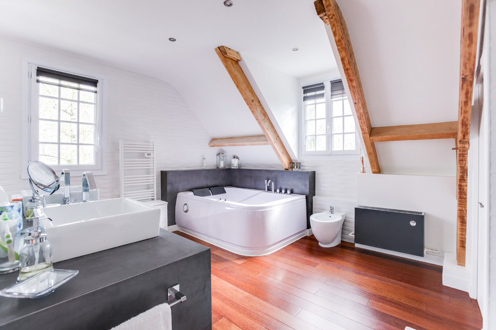 This is an example of a contemporary bathroom in Paris with a hot tub, a built-in shower, white tiles, white walls, medium hardwood flooring, a trough sink, onyx worktops, brown floors and a hinged door.