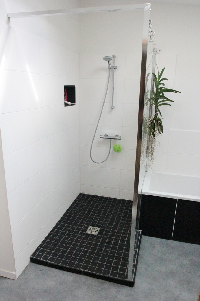 This is an example of a small contemporary ensuite bathroom in Toulouse with glass-front cabinets, a built-in bath, a corner shower, white tiles and white walls.