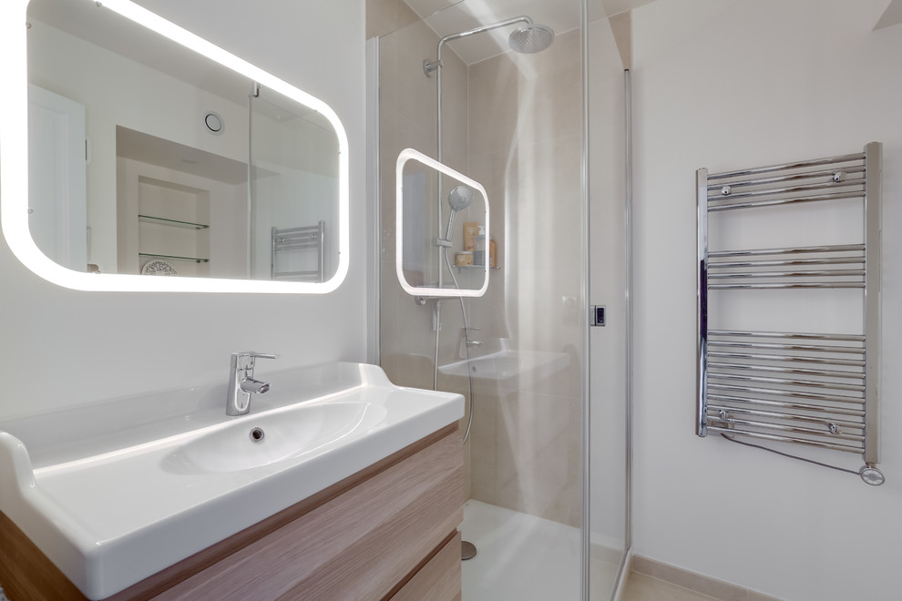 Exemple d'une salle de bain tendance en bois clair avec un placard à porte plane, une douche d'angle, un carrelage beige, un mur blanc, un plan vasque, un sol beige et une cabine de douche à porte battante.