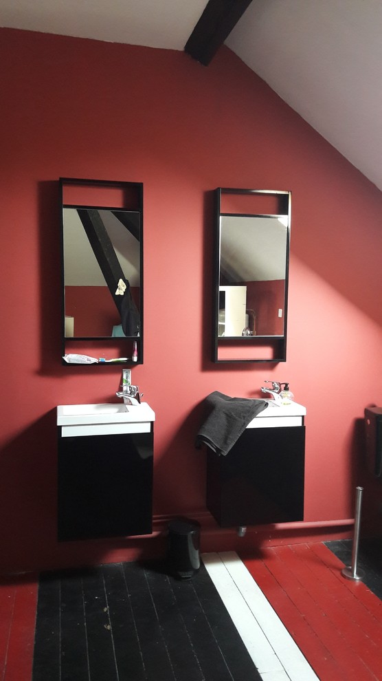 Пример оригинального дизайна: большая главная ванная комната в современном стиле с стеклянными фасадами, черными фасадами, розовой плиткой, розовыми стенами, деревянным полом, подвесной раковиной, стеклянной столешницей и разноцветным полом