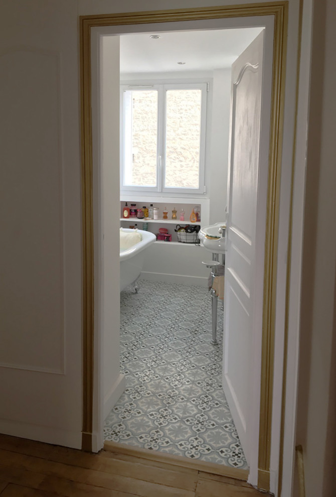 Ispirazione per una stanza da bagno con doccia minimalista di medie dimensioni con ante bianche, vasca/doccia, pareti bianche, pavimento in cementine, lavabo a colonna, pavimento blu, un lavabo e soffitto a cassettoni