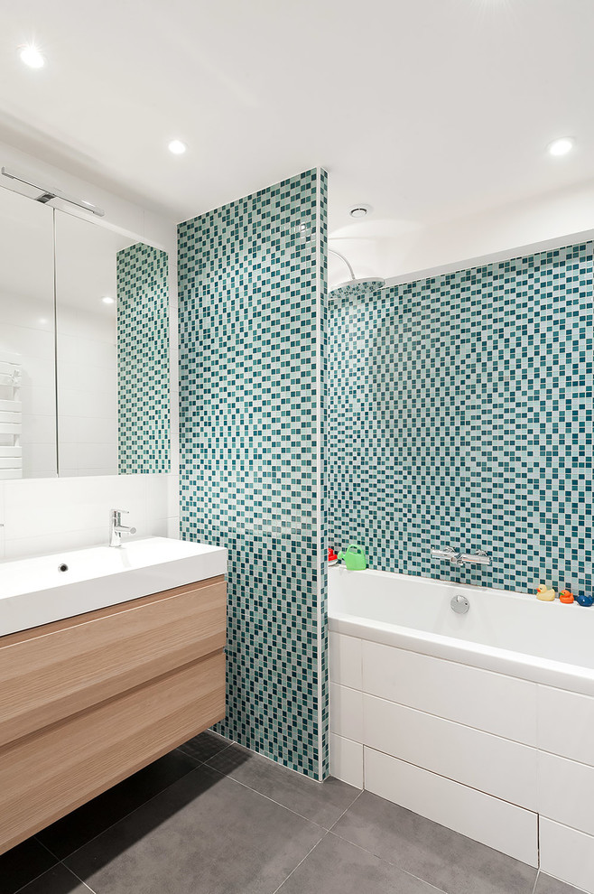 Diseño de cuarto de baño principal y azulejo de dos tonos escandinavo de tamaño medio con bañera encastrada, baldosas y/o azulejos azules, baldosas y/o azulejos en mosaico, paredes blancas, lavabo bajoencimera y combinación de ducha y bañera