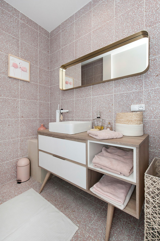 Idéer för små funkis beige badrum för barn, med vita skåp, en dusch i en alkov, rosa kakel, rosa väggar, ett fristående handfat, släta luckor, en toalettstol med separat cisternkåpa, keramikplattor, klinkergolv i keramik, laminatbänkskiva, rosa golv och dusch med skjutdörr