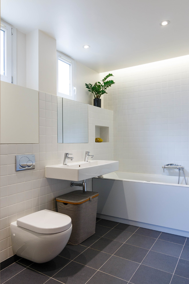 Mittelgroßes Modernes Badezimmer En Suite mit Wandwaschbecken, Wandtoilette, weißen Fliesen, weißer Wandfarbe und Einbaubadewanne in Paris