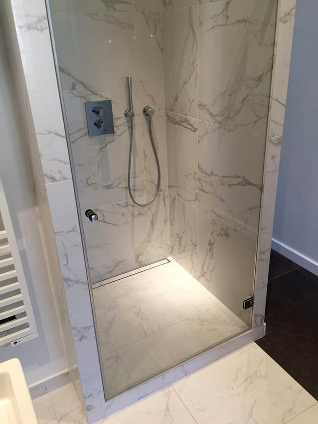 Inredning av ett klassiskt mellanstort badrum med dusch, med en kantlös dusch, marmorkakel, marmorgolv, vit kakel, vita väggar, kaklad bänkskiva, vitt golv och dusch med gångjärnsdörr