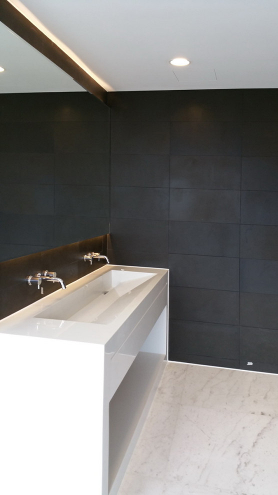 На фото: ванная комната с черной плиткой, плиткой из сланца, черными стенами, столешницей из искусственного камня, белым полом, белой столешницей и тумбой под две раковины