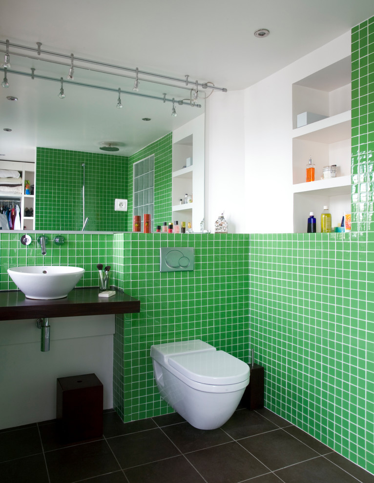 Modern inredning av ett mellanstort badrum med dusch, med ett fristående handfat, en vägghängd toalettstol, grön kakel, vita väggar, öppna hyllor, vita skåp, en öppen dusch och med dusch som är öppen