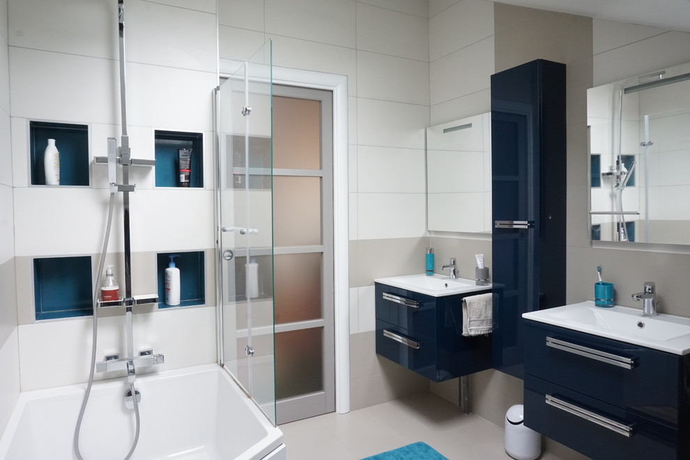 Idées déco pour une grande salle de bain contemporaine pour enfant avec une baignoire encastrée, un espace douche bain, WC suspendus, un carrelage beige, un lavabo encastré, un sol beige, un mur beige et des portes de placard bleues.