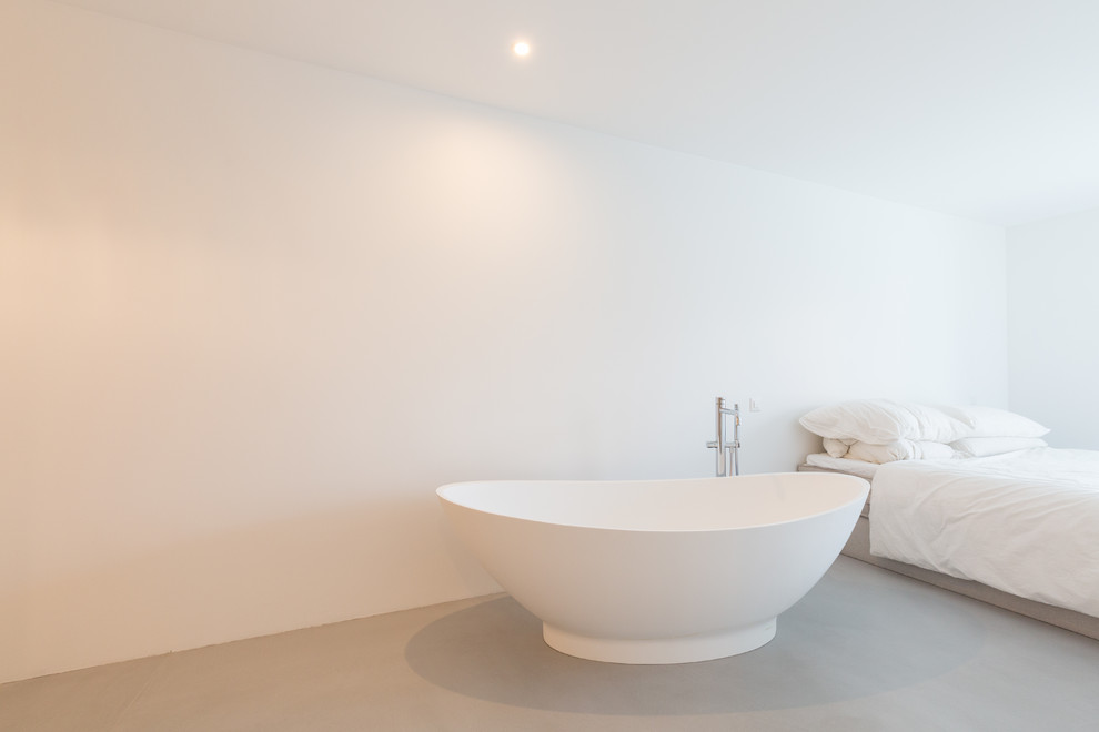 Réalisation d'une salle de bain design avec sol en béton ciré et un sol gris.