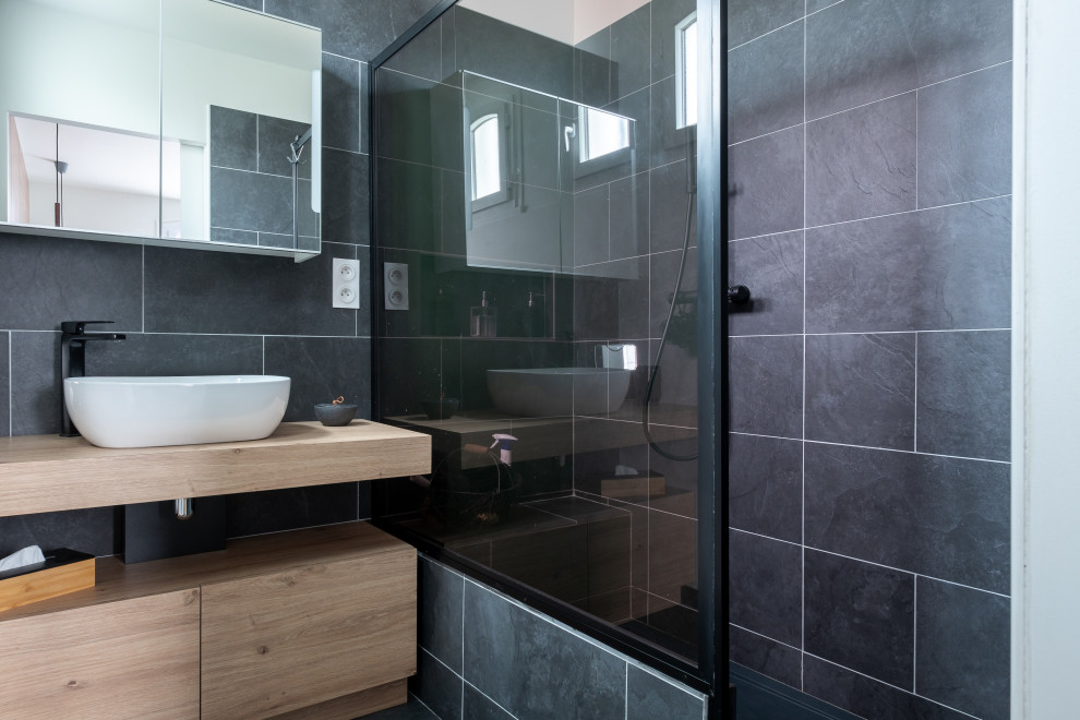 Idéer för ett modernt badrum, med skåp i ljust trä, svart kakel, skifferkakel, svarta väggar, klinkergolv i keramik, laminatbänkskiva och svart golv