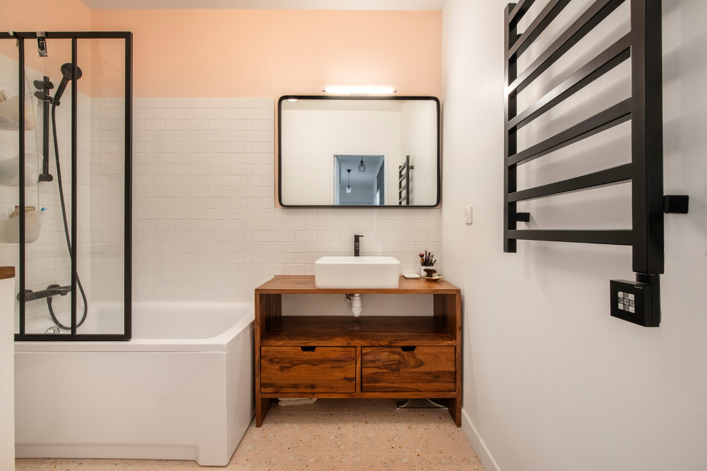 Пример оригинального дизайна: большая главная ванная комната со стиральной машиной в стиле модернизм с плоскими фасадами, фасадами цвета дерева среднего тона, накладной ванной, душем над ванной, белой плиткой, керамической плиткой, белыми стенами, полом из терраццо, настольной раковиной, столешницей из дерева, разноцветным полом, открытым душем, коричневой столешницей, тумбой под одну раковину и напольной тумбой