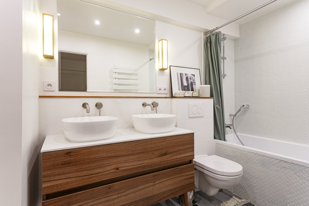 Bild på ett mellanstort funkis vit vitt en-suite badrum, med släta luckor, skåp i mörkt trä, ett hörnbadkar, en dusch/badkar-kombination, vit kakel, marmorkakel, vita väggar, cementgolv, ett konsol handfat, grått golv och dusch med duschdraperi