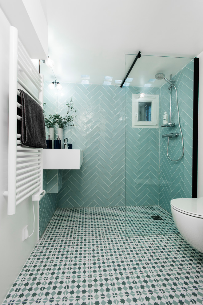 Inredning av ett minimalistiskt litet vit vitt badrum med dusch, med en kantlös dusch, en vägghängd toalettstol, blå kakel, keramikplattor, vita väggar, klinkergolv i keramik, ett väggmonterat handfat, bänkskiva i akrylsten, blått golv och med dusch som är öppen