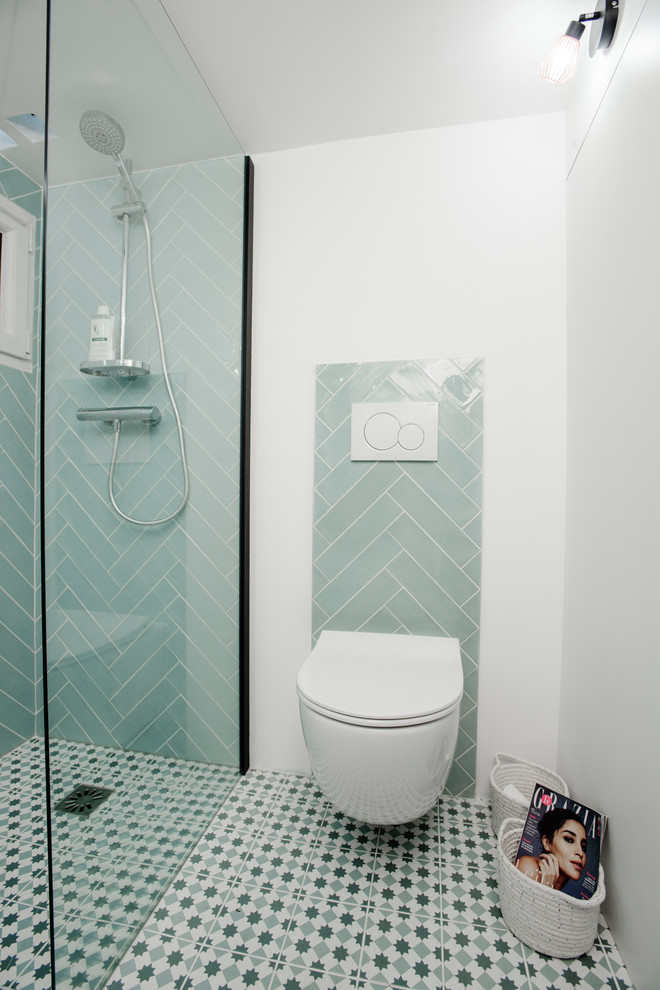 На фото: маленькая ванная комната в скандинавском стиле с душем без бортиков, инсталляцией, синей плиткой, керамической плиткой, белыми стенами, полом из керамической плитки, душевой кабиной, подвесной раковиной, столешницей из искусственного камня, синим полом, открытым душем и белой столешницей для на участке и в саду