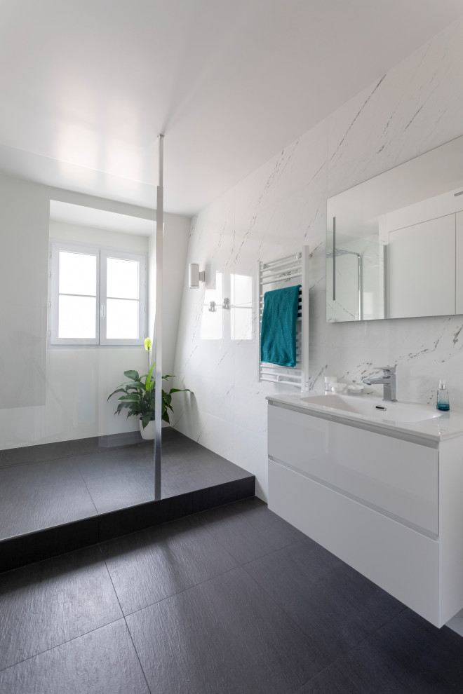Expansive contemporary shower room bathroom in Other with beaded cabinets, white cabinets, a double shower, a one-piece toilet, black and white tiles, ceramic tiles, white walls, ceramic flooring, a wall-mounted sink, quartz worktops, black floors, an open shower and white worktops.