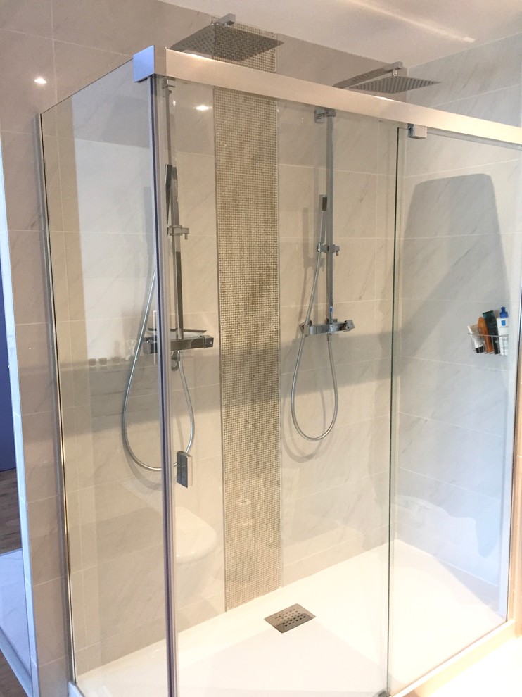 Modelo de cuarto de baño contemporáneo de tamaño medio con ducha doble, sanitario de pared, baldosas y/o azulejos blancos, paredes blancas, suelo de mármol, aseo y ducha, lavabo bajoencimera y encimera de vidrio