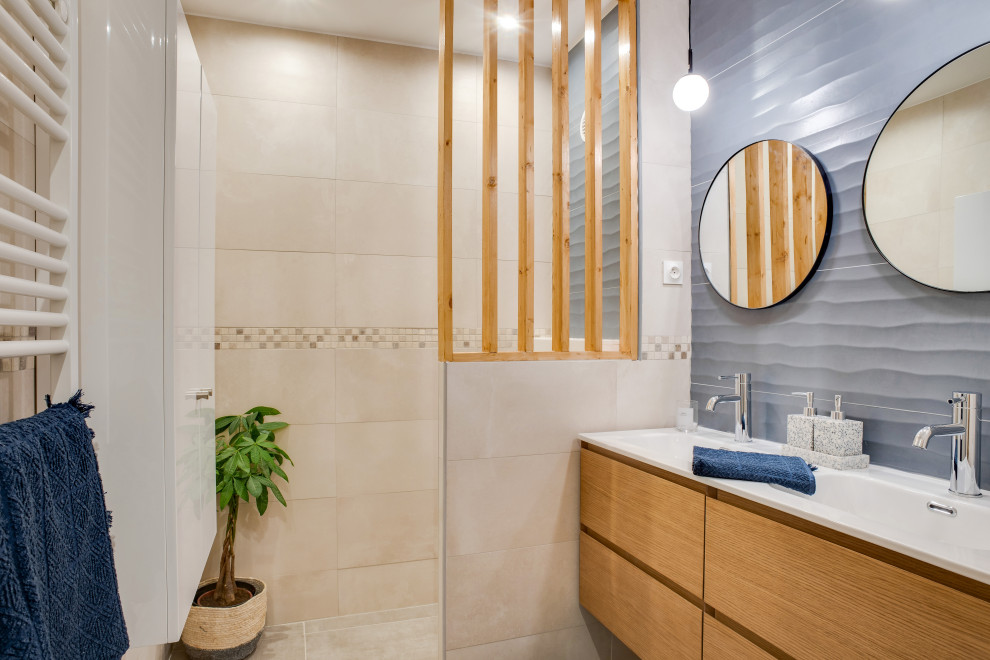 Inspiration pour une grande salle de bain design en bois clair avec WC suspendus, un carrelage beige, des carreaux de céramique, un mur bleu, une vasque, une cabine de douche à porte battante, un plan de toilette beige, meuble double vasque et meuble-lavabo suspendu.