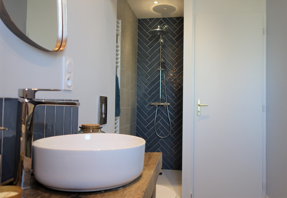 This is an example of a medium sized rural ensuite bathroom in Nantes with a walk-in shower, a wall mounted toilet, blue tiles, a built-in sink, open cabinets, matchstick tiles, blue walls, terrazzo flooring, wooden worktops, grey floors, an open shower, brown worktops and double sinks.