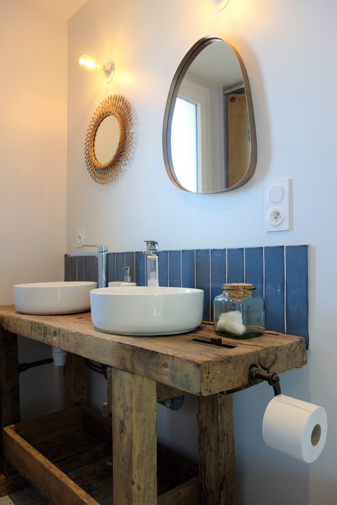 Inspiration for a medium sized rural ensuite bathroom in Nantes with a walk-in shower, a wall mounted toilet, blue tiles, a built-in sink, open cabinets, matchstick tiles, blue walls, terrazzo flooring, wooden worktops, grey floors, an open shower, brown worktops and double sinks.