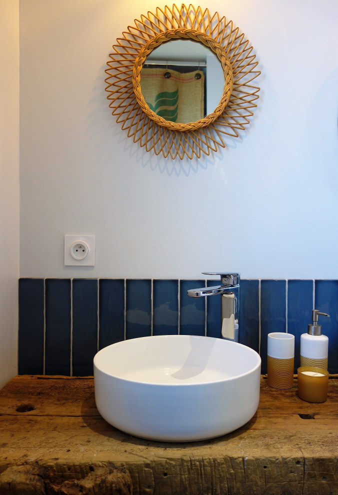 Inredning av ett lantligt mellanstort brun brunt en-suite badrum, med öppna hyllor, en öppen dusch, en vägghängd toalettstol, blå kakel, stickkakel, blå väggar, terrazzogolv, ett nedsänkt handfat, träbänkskiva, grått golv och med dusch som är öppen