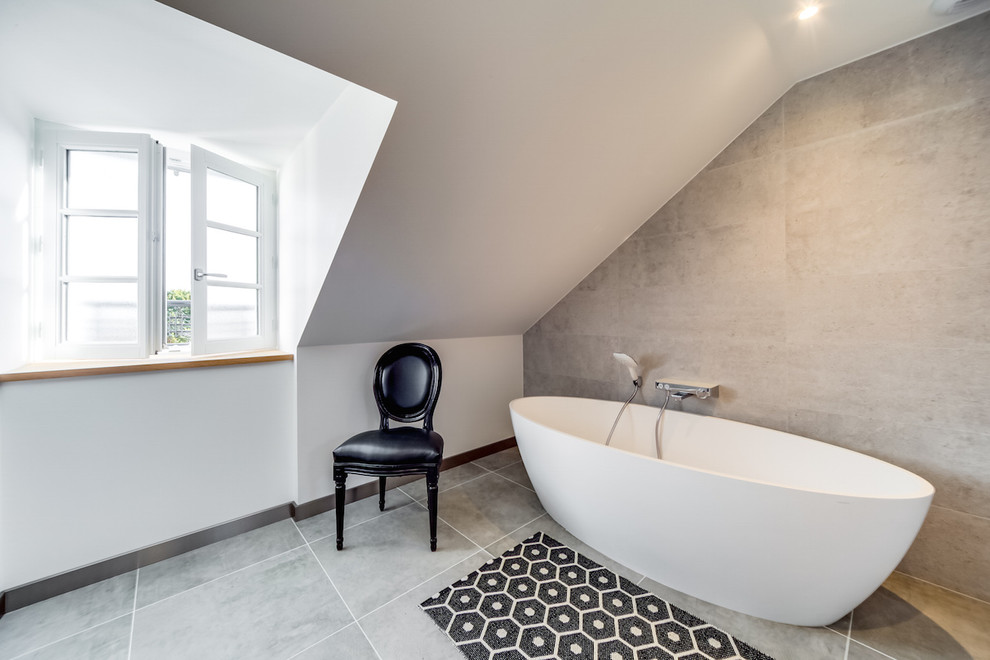 Small contemporary ensuite bathroom in Other with a built-in bath, grey tiles, ceramic tiles, ceramic flooring, a console sink, grey floors and brown walls.
