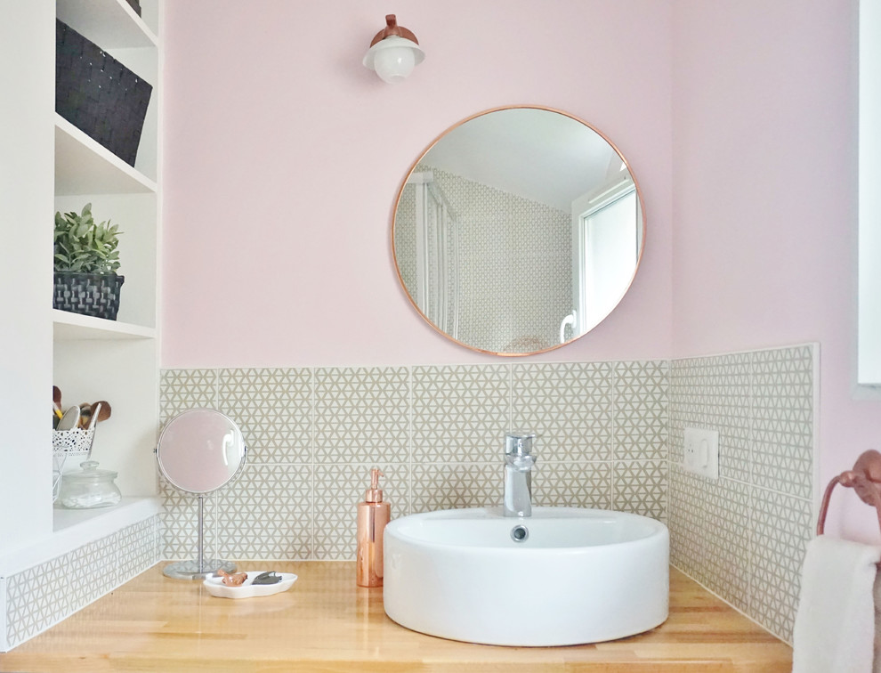 Idéer för att renovera ett mellanstort funkis badrum med dusch, med öppna hyllor, vita skåp, en vägghängd toalettstol, gul kakel, cementkakel, rosa väggar, ljust trägolv, ett fristående handfat och träbänkskiva