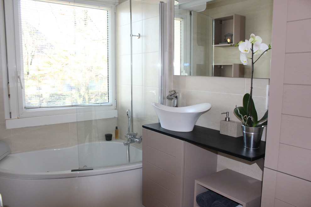 Aménagement d'une petite salle de bain principale contemporaine avec un bain bouillonnant, un carrelage beige, un mur beige, un sol en vinyl, un plan de toilette en quartz, un combiné douche/baignoire et une vasque.