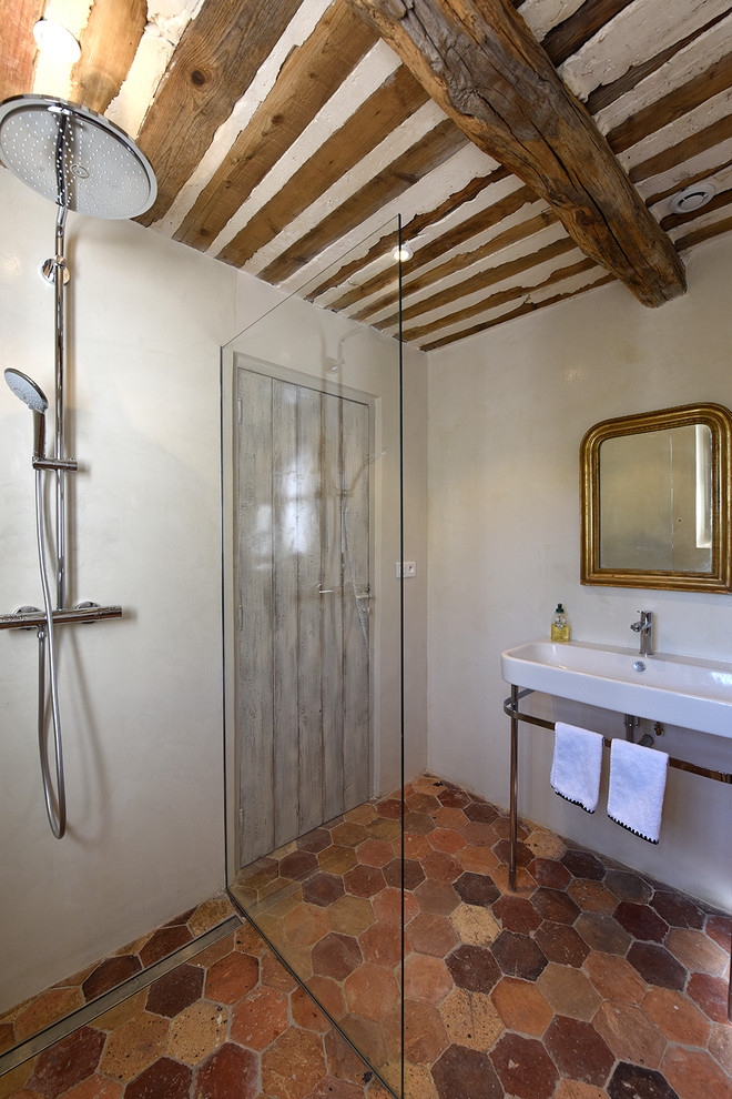 Свежая идея для дизайна: ванная комната в средиземноморском стиле с угловым душем, бежевыми стенами, полом из терракотовой плитки, душевой кабиной, консольной раковиной, красным полом и открытым душем - отличное фото интерьера