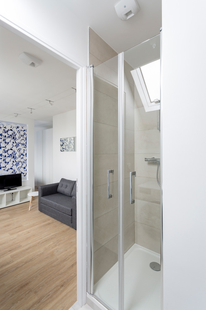 На фото: ванная комната в современном стиле с плоскими фасадами, серыми фасадами, душем в нише, унитазом-моноблоком, белой плиткой, керамической плиткой, белыми стенами, бетонным полом, душевой кабиной, монолитной раковиной, столешницей из искусственного камня, серым полом и душем с распашными дверями