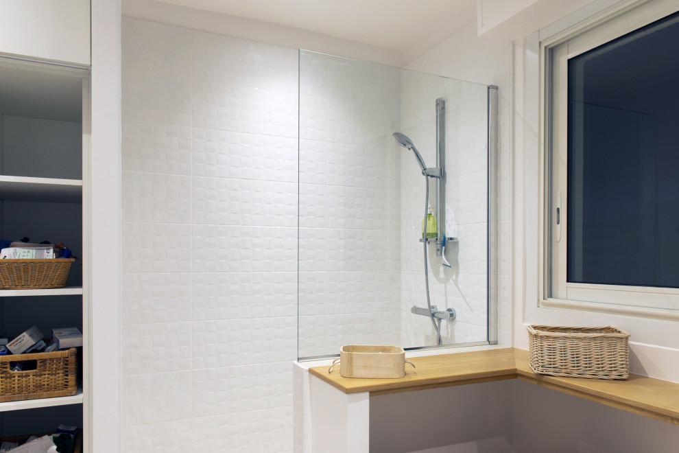 Inspiration för stora moderna vitt badrum med dusch, med öppna hyllor, beige skåp, en kantlös dusch, vit kakel, keramikplattor, blå väggar, cementgolv, ett avlångt handfat, bänkskiva i akrylsten, beiget golv och med dusch som är öppen