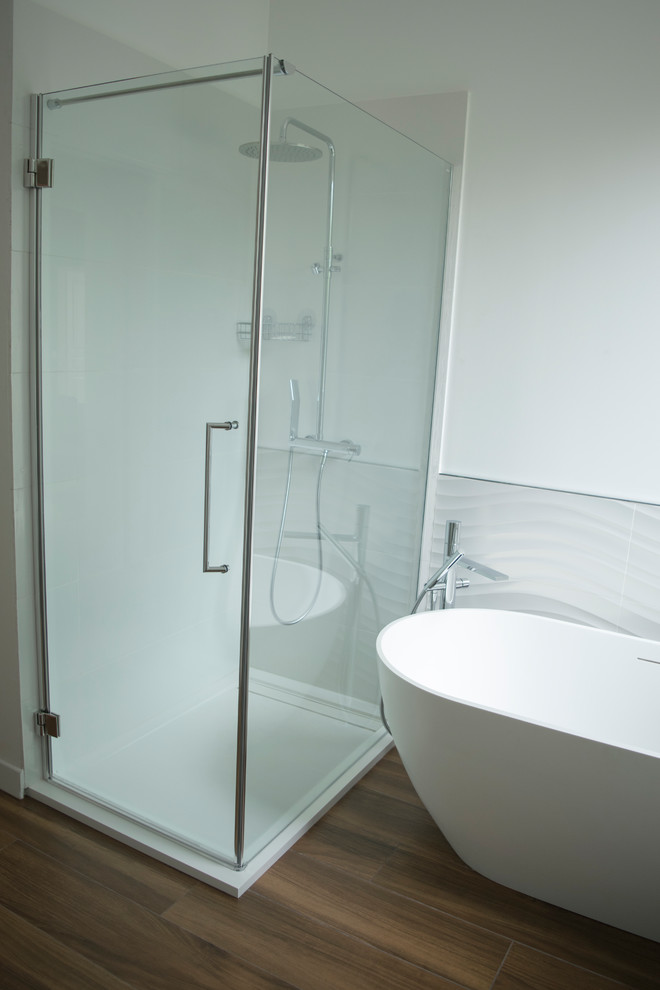Bild på ett mellanstort funkis en-suite badrum, med ett platsbyggt badkar, en kantlös dusch, vit kakel, porslinskakel, vita väggar, mörkt trägolv, ett konsol handfat, brunt golv och dusch med gångjärnsdörr