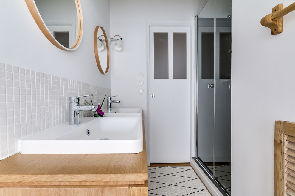 Modelo de cuarto de baño escandinavo pequeño con puertas de armario con efecto envejecido, ducha a ras de suelo, baldosas y/o azulejos beige, baldosas y/o azulejos en mosaico, paredes blancas, aseo y ducha y lavabo sobreencimera