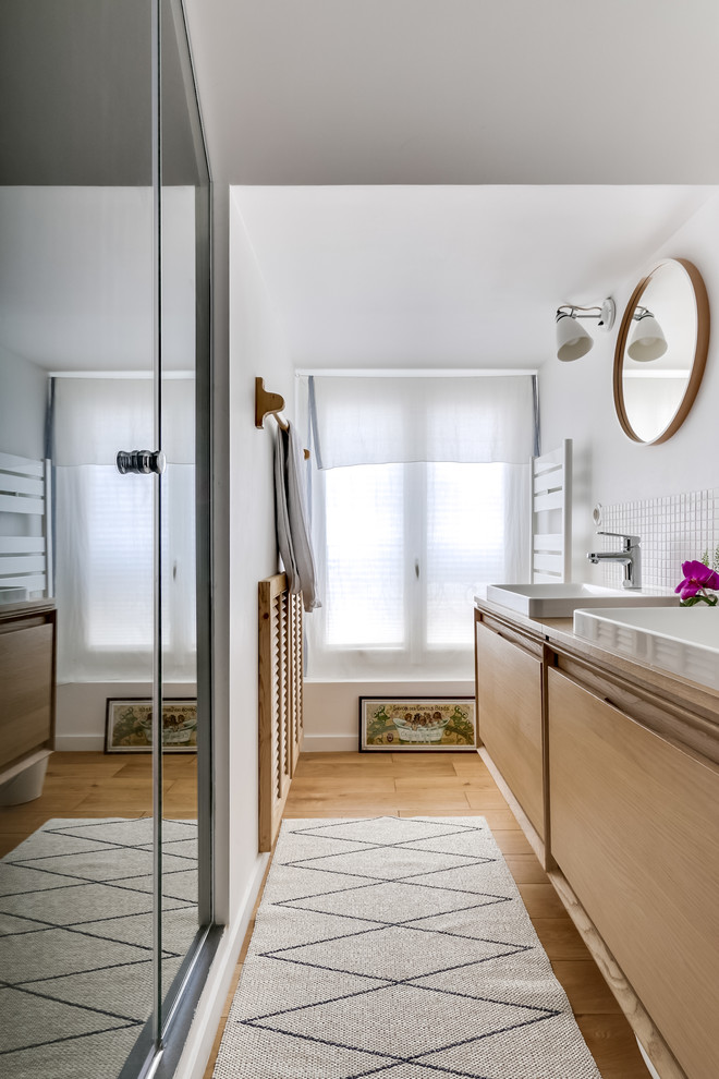 This is an example of a small scandi shower room bathroom in Paris with distressed cabinets, a built-in shower, beige tiles, mosaic tiles, white walls, a vessel sink, medium hardwood flooring and flat-panel cabinets.